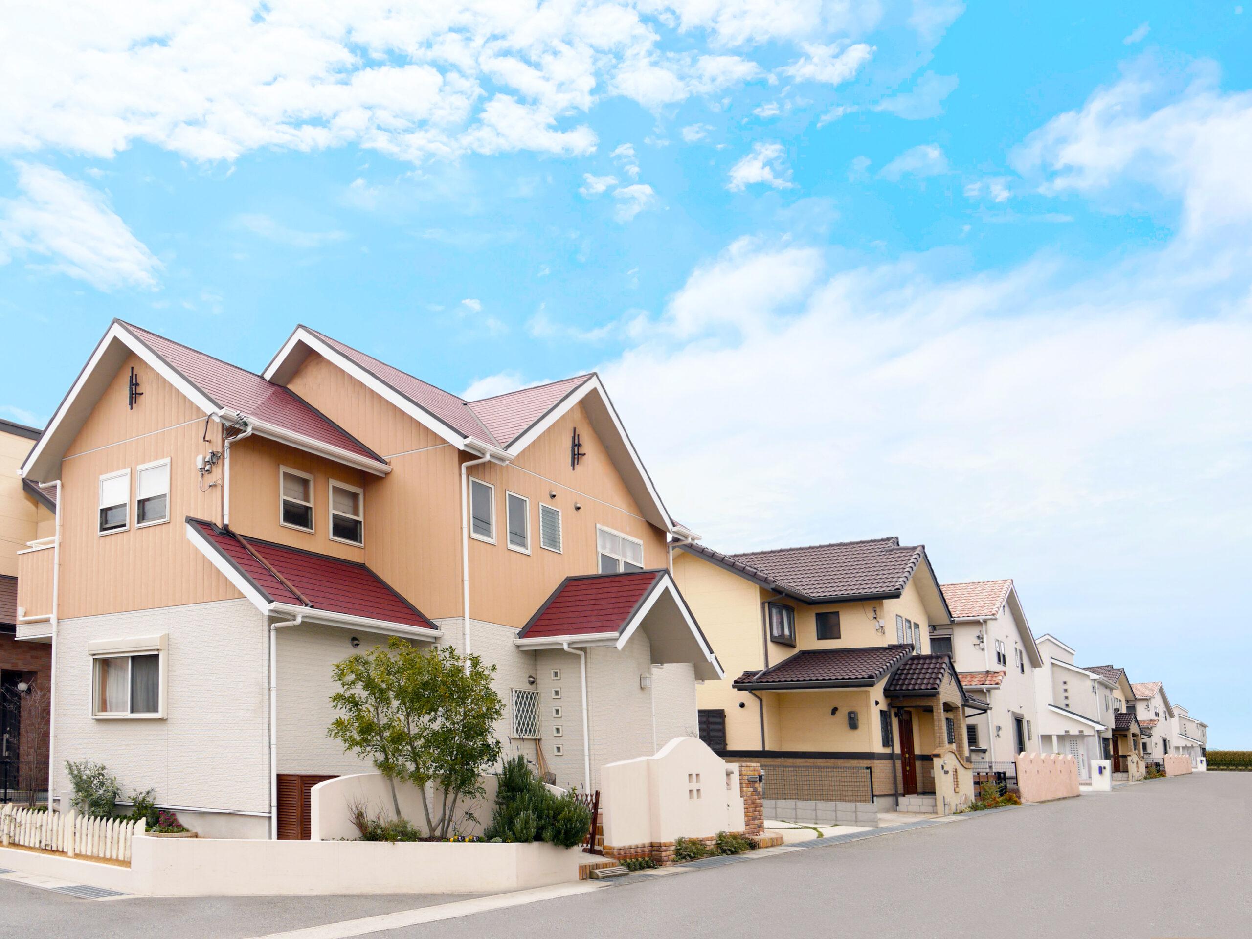 青空の下に建ち並ぶ戸建て住宅街の風景